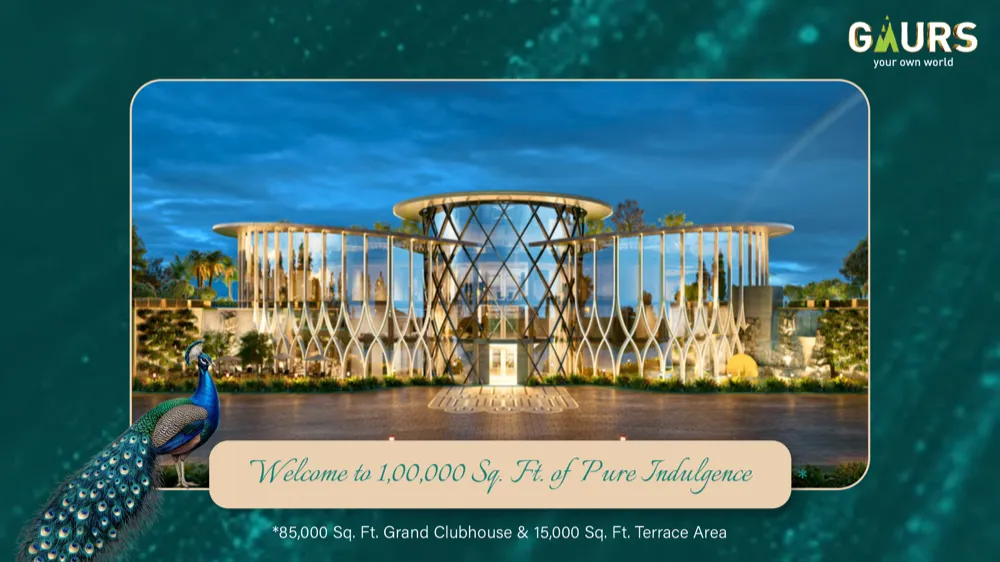 Gaur Alaris Grand Clubhouse exterior at dusk, glass-and-steel structure with peacock branding and Gaurs logo